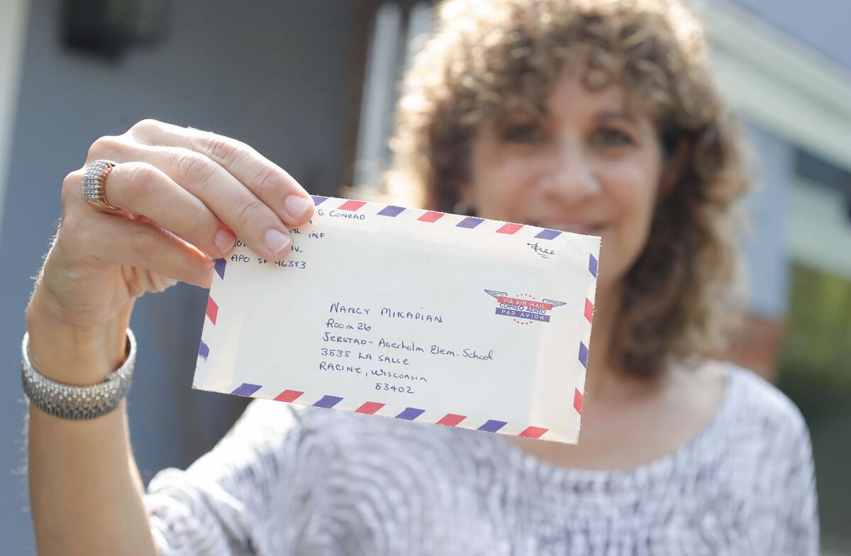 Nancy Mikaelian Madey shows the response letter sent to her from Vietnam soldier Michael Conrad 50 years ago.