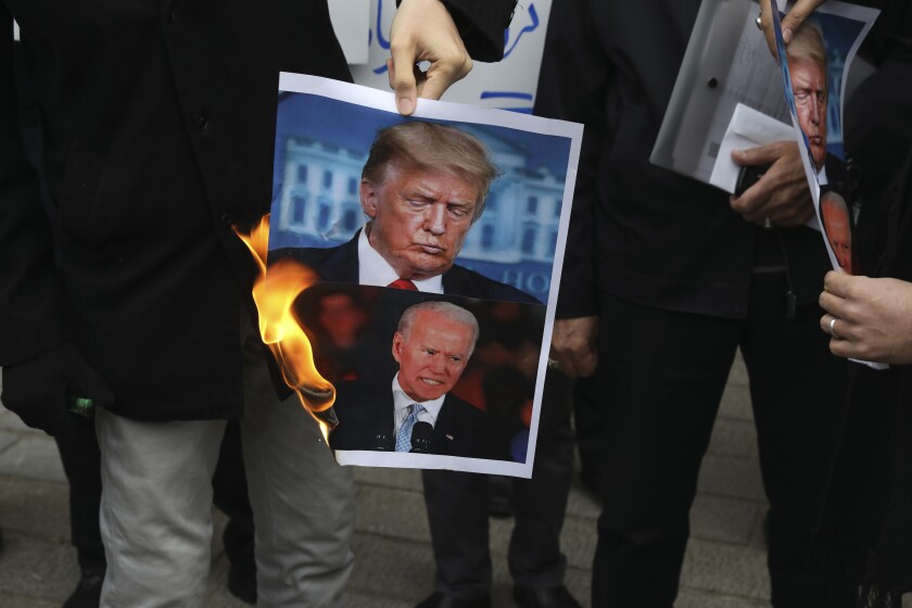 Protesters burn pictures of President Trump and President-elect Joe Biden in Tehran on Saturday.