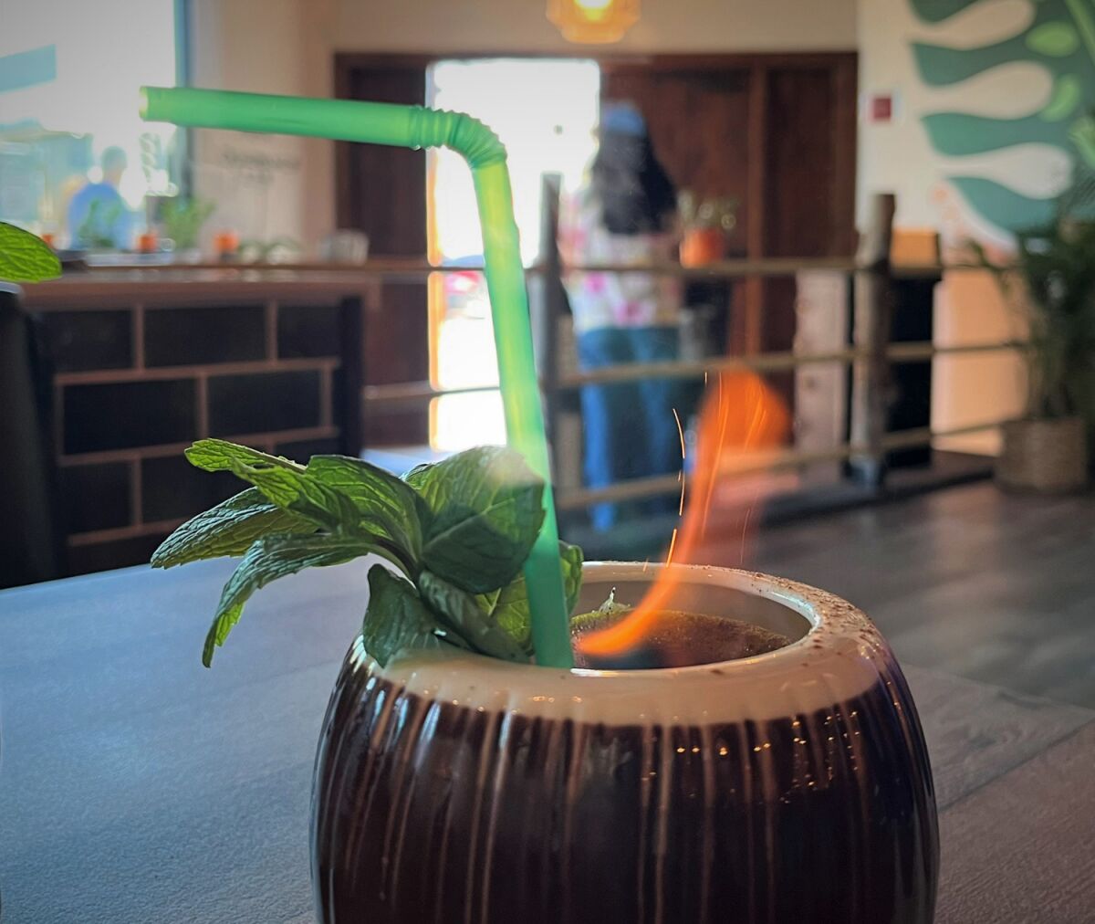 Una lima quemada en un coctel de coco en una lima en el bar Coconut Restaurant en Chula Vista.