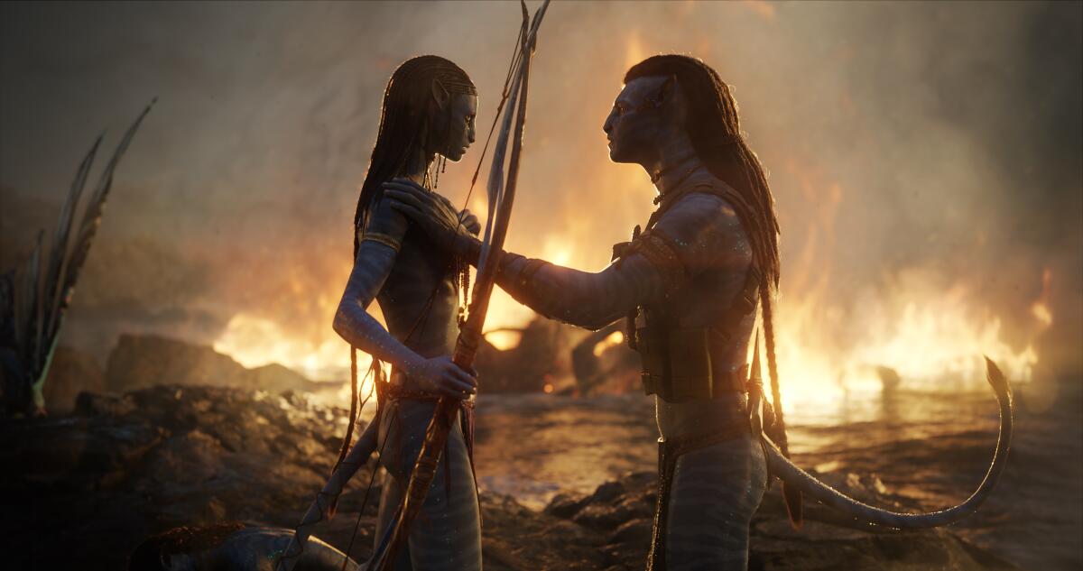 A blue, CGI woman holding a bow and arrow while interacting with a blue, CGI man in a fiery landscape