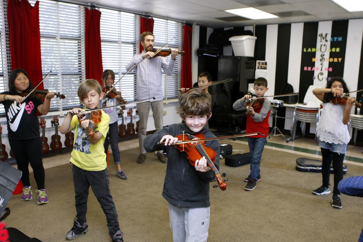 Roosevelt Elementary School music teacher Jacob Boyd poses with his violin class at the Burbank school on Tuesday, Feb. 14, 2017.