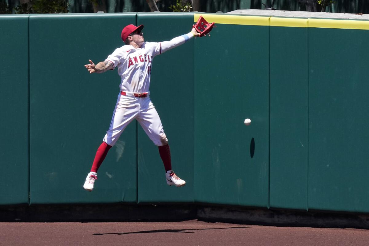 Center fielder Mickey Moniak leaps for the ball at the warning track at Angel Stadium