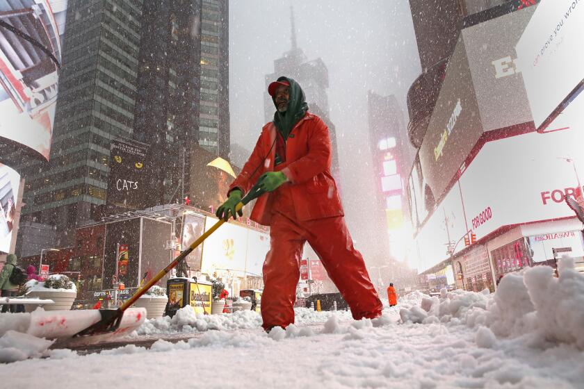 New York city employee Ronney Wade shovels snow in Time Square on Tuesday morning.