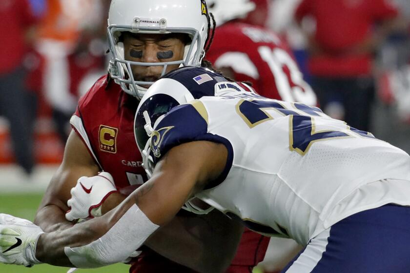 Cardinals wide receiver Larry Fitzgerald is hit from Rams cornerback Trumaine Johnson during the second half.