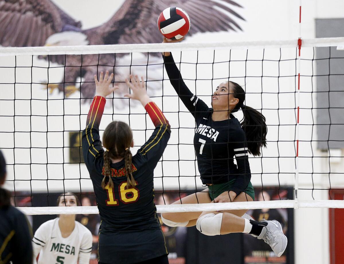 Costa Mesa's Aubrey Spallone (7) tips a ball past Estancia's Mailee Blanchard (16) in the Battle for the Bell match Tuesday.