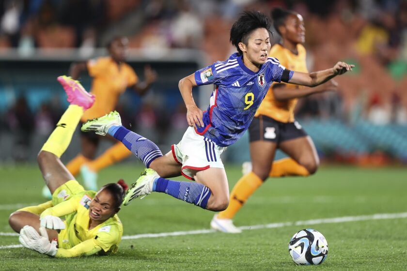 La japonesa Riko Ueki (derecha) recibe una falta de la portera de Zambia, Catherine Musonda, durante el partido del Grupo C del Mundial de Nueva Zelanda y Australia que enfrentó a ambas selecciones, en Hamilton, Nueva Zelanda, el 22 de julio de 2023. (AP Foto/Juan Mendez)