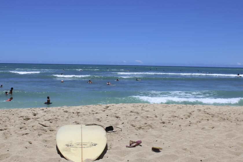 FILE - A surfboard lies on the sand on the sand at a beach known as White Plains in Ewa Beach, Hawaii, May 12, 2023. A judge has halted plans for an artificial wave pool until developers can revise an environmental assessment to address concerns raised by Native Hawaiians and others who say the project is unnecessary in the birthplace of surfing and a waste of water. (AP Photo/Jennifer Sinco Kelleher, File)