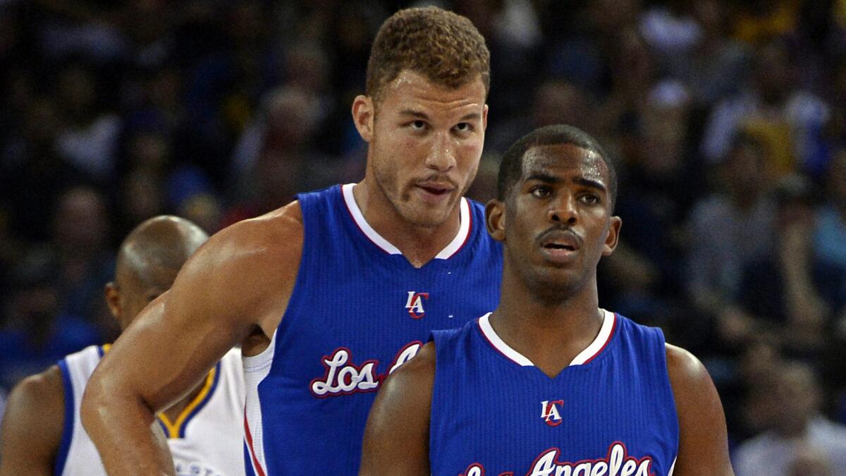 Clippers teammates Blake Griffin, left, and Chris Paul have a quick chat during a break in play against the Golden State Warriors on Nov. 5.