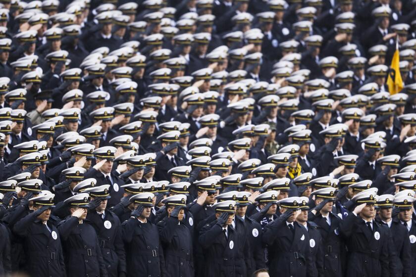 Navy midshipmen salute ahead of an NCAA college football game against Army, Saturday, Dec. 14, 2019, in Philadelphia. (AP Photo/Matt Slocum)
