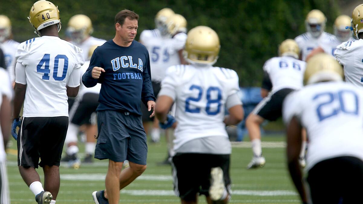 Coach Jim Mora watches the Bruins go through drills during their training camp in Westwood.