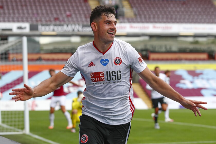 Sheffield United's John Egan celebrates after scoring his side's opening goal during the English Premier League soccer match between Burnley and Sheffield United, at Turf Moor Stadium in Burnley, England, Sunday, July 5, 2020. (Clive Brunskill/Pool Photo via AP)
