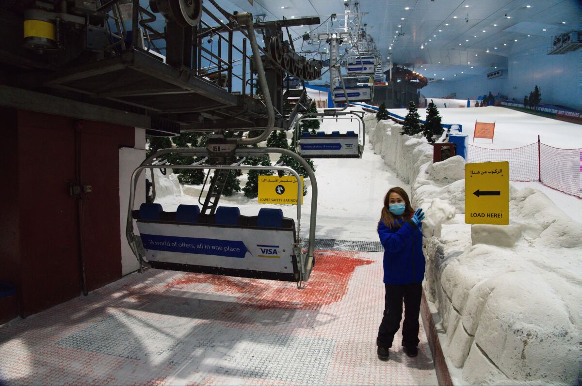 FILE - An employee at Ski Dubai inside the Mall of the Emirates operated by the Majid Al Futtaim company, waits for skiers near the chair lift in Dubai, United Arab Emirates, May 27, 2020. A special judicial committee has been appointed to weigh in on potential legal disputes regarding the inheritance of Majid Al Futtaim, whose eponymous company operates more than two dozen malls region-wide and is seen as a key pillar of Dubai's tourism and economic growth, the company confirmed in a statement to the The Associated Press on Monday, Feb. 14, 2022. (AP Photo/Jon Gambrell, File)