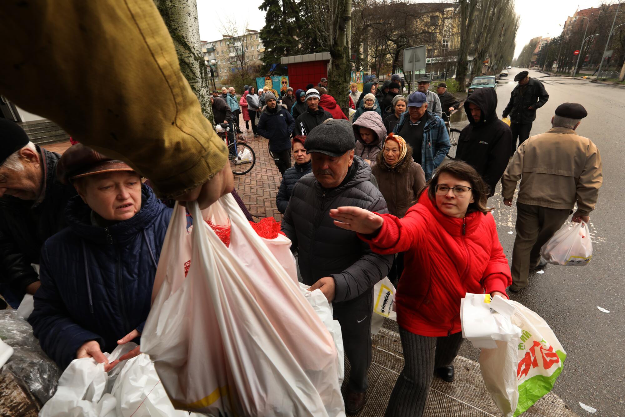 A food giveaway drew a long line of residents on a street.
