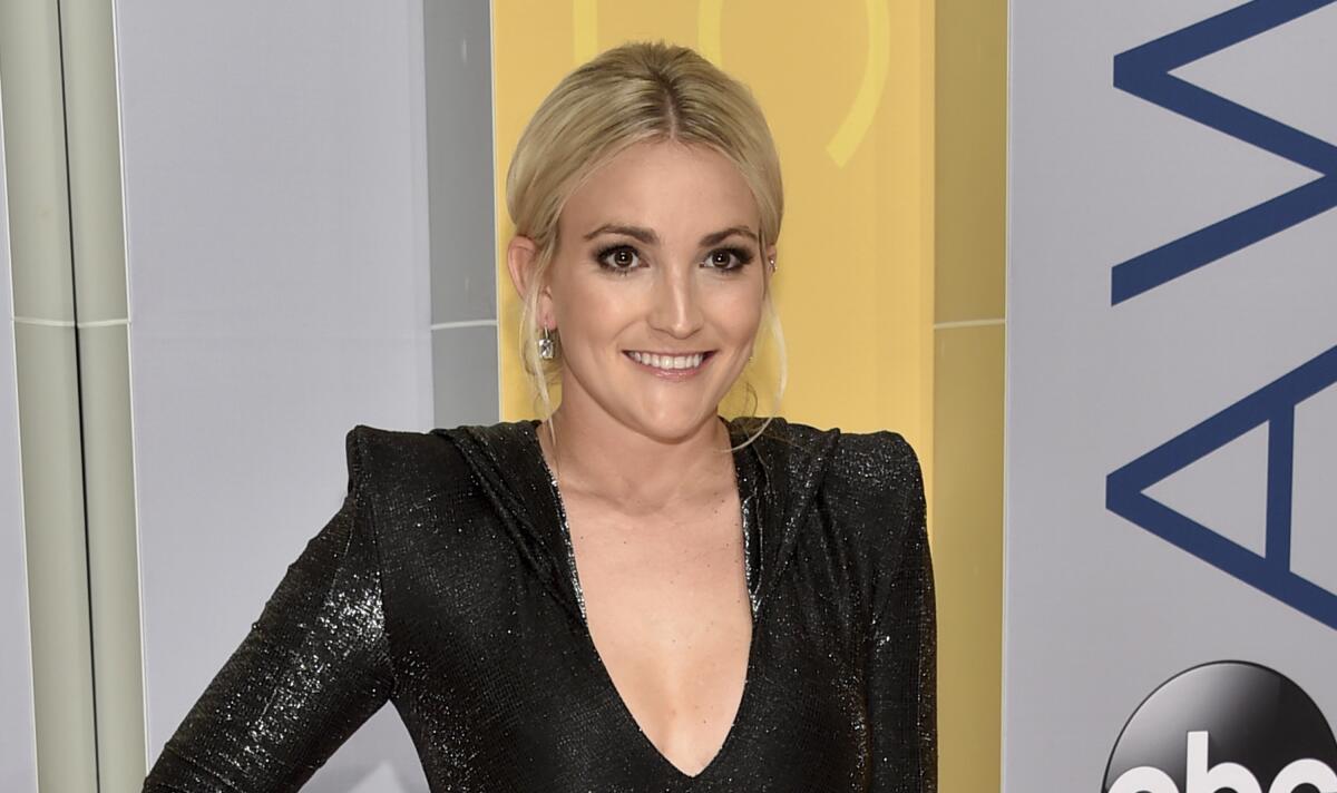 Jamie Lynn Spears in a black long sleeve dress with shoulder pads and a deep neckline