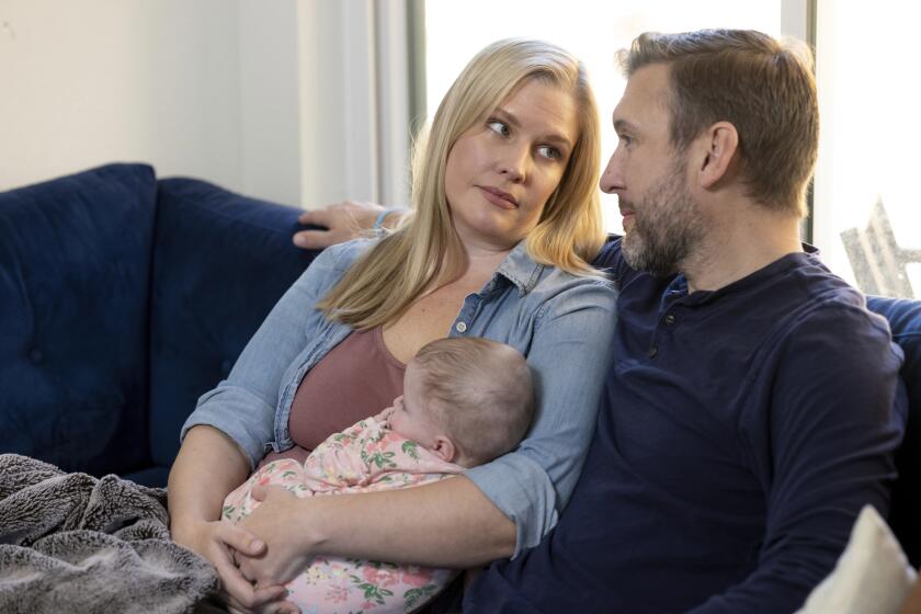 Kaitlyn Kash and husband Cory Kash sit at home with their 4-month-old daughter, Sunday, Dec. 17, 2023, in Austin, Texas. Kaitlyn Kash has joined as a plaintiff on the Zurawski v. State of Texas case, a lawsuit that looks to clarify the scope of the state's abortion ban. (AP Photo/Stephen Spillman)