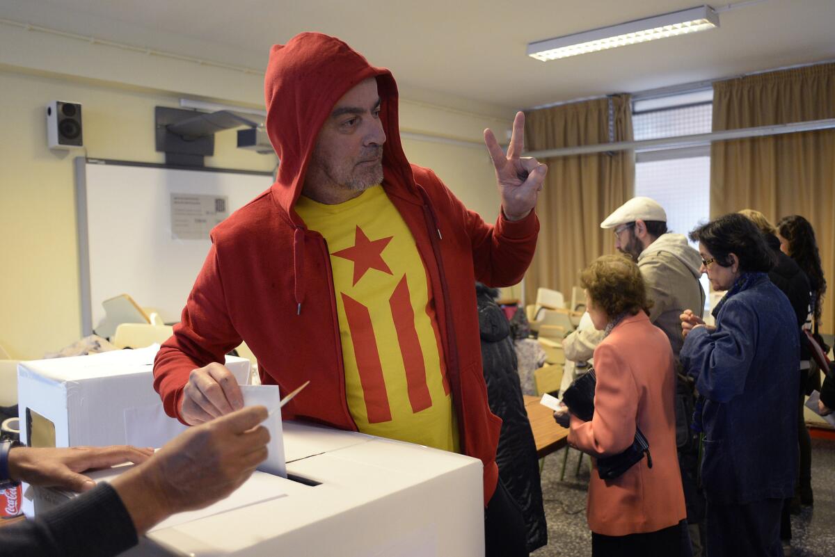 A man with a pro-independence Catalan flag on his T-shirt casts his vote in Barcelona on Sunday in an unofficial referendum asking whether the Catalonia region should break away from Spain.