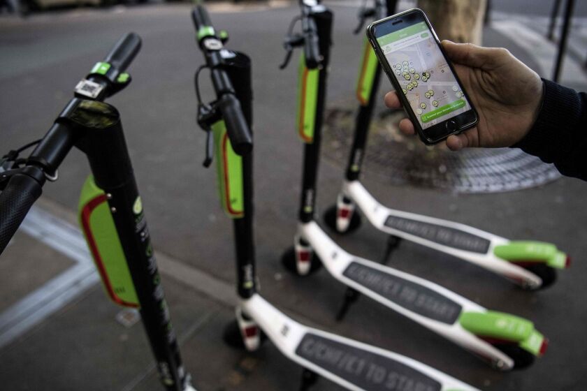 A man shows the mobile application allowing to check the availability of electric scooters of the US company Lime on the day of their launch in Paris on June 22, 2018. / AFP PHOTO / Christophe ARCHAMBAULTCHRISTOPHE ARCHAMBAULT/AFP/Getty Images ** OUTS - ELSENT, FPG, CM - OUTS * NM, PH, VA if sourced by CT, LA or MoD **