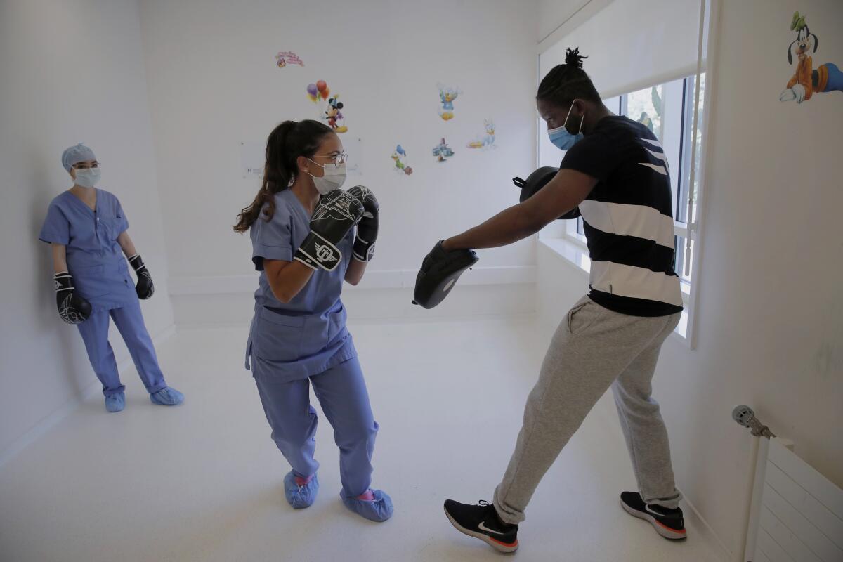 La enfermera Kenza Benour practica con el excampeón mundial de boxeo Hassan N'Dam en el hospital Villeneuve -Saint-Georges de las afueras de París el 27 de mayo del 2020.