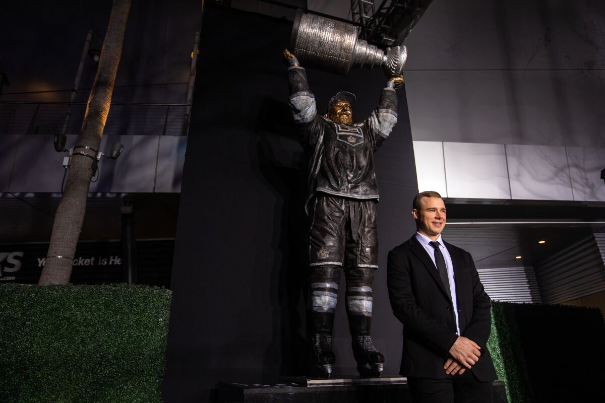 Dustin Brown se tient devant une statue à son image devant la Crypto.com Arena.