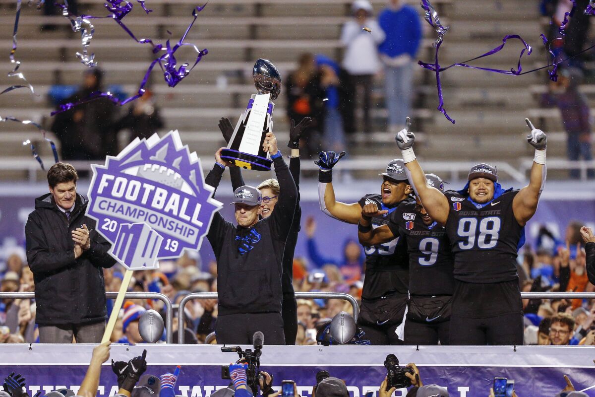 Boise State coach Bryan Harsin holds up the Mountain West Championship trophy.