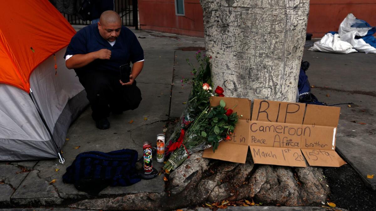 Fernando Avila kneels at a makeshift memorial for Charly Leundeu Keunang a day after the 43-year-old was shot and killed by LAPD officers on skid row in 2015.