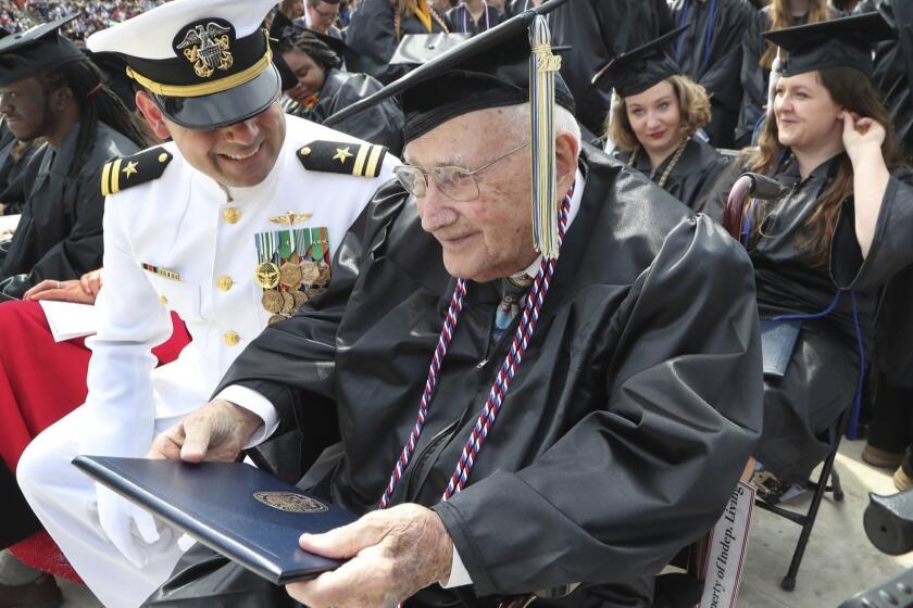 World War II veteran Bob Barger, assisted by Haraz Ghanbari, University of Toledo director of military and veteran affairs, left, smiles after receiving his diploma at the commencement ceremony at the university, Saturday, May 5, 2018, in Toledo, Ohio. Now, 68 years since he last sat in a classroom, Barger graduated after a review of his transcripts from the late 1940s showed he completed enough courses to qualify for an associate's degree â a two-year diploma not offered when he was still in school. "It was something I never dreamed of," the 96-year-old Barger said. "I knew I couldn't go back to school now. The university took a look at Barger's old school records because of a friendship he struck up with Ghanbari. (AP Photo/Carlos Osorio)
