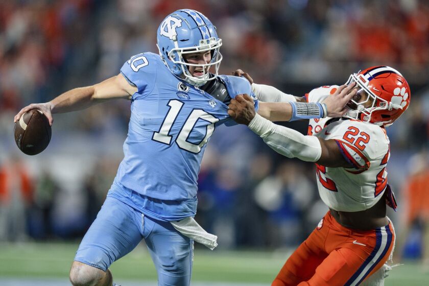 North Carolina quarterback Drake Maye (10) is brought down by Clemson linebacker Trenton Simpson (22) in the first half during the Atlantic Coast Conference championship NCAA college football game on Saturday, Dec. 3, 2022, in Charlotte, N.C. (AP Photo/Jacob Kupferman)