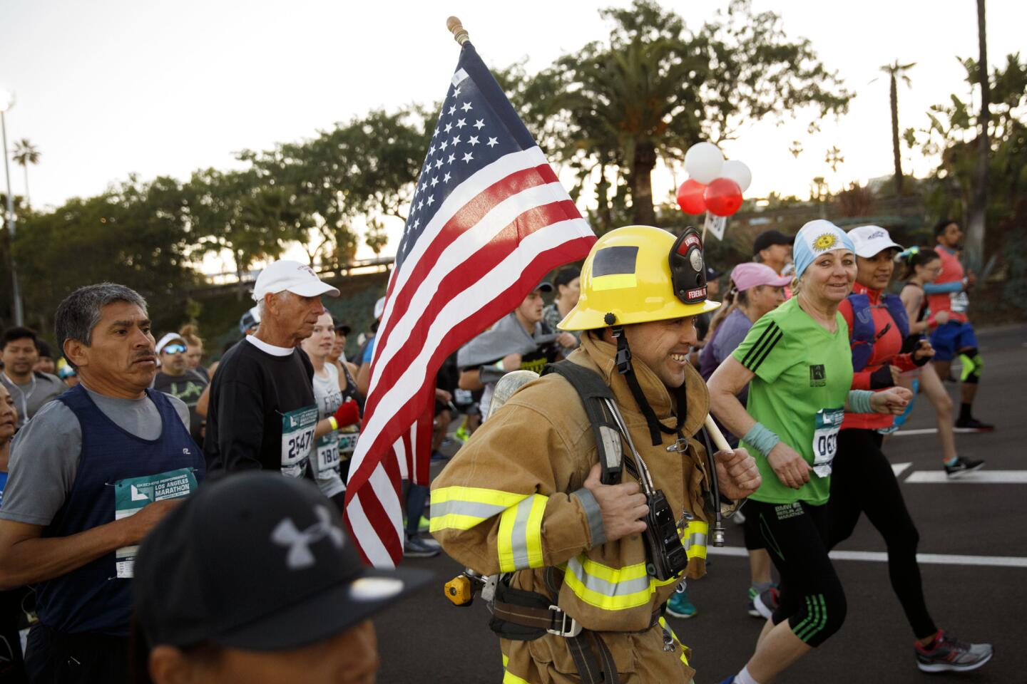 A man runs in full firefighting turnout gear after the start of the 33rd L.A. Marathon.