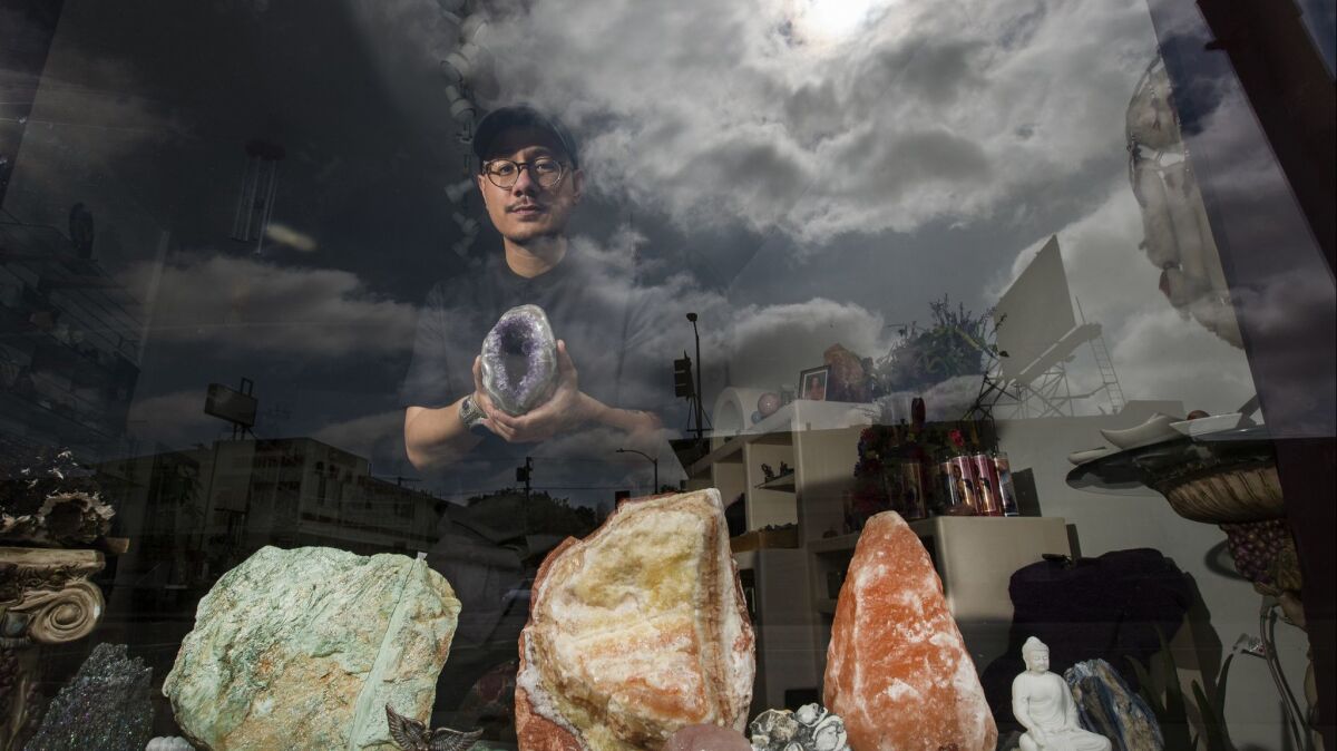 Julian Sambrano, owner of Mostly Angels L.A., photographed with crystals on display at the store. Mostly Angels has sold crystals, candles and more for 30 years in Los Angeles. Sambrano took it over in 2017.