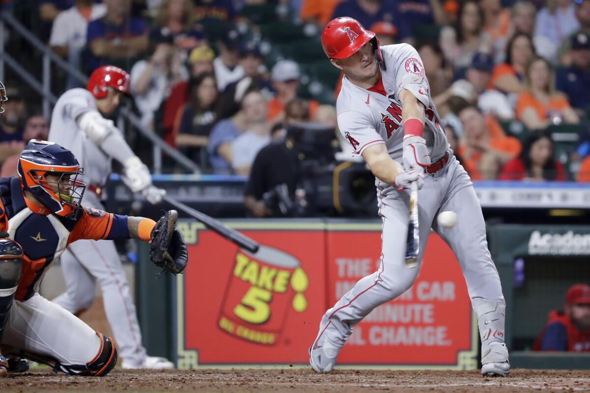 Angels star Mike Trout connects for a two-run home run in front of Houston Astros catcher Martin Maldonado.