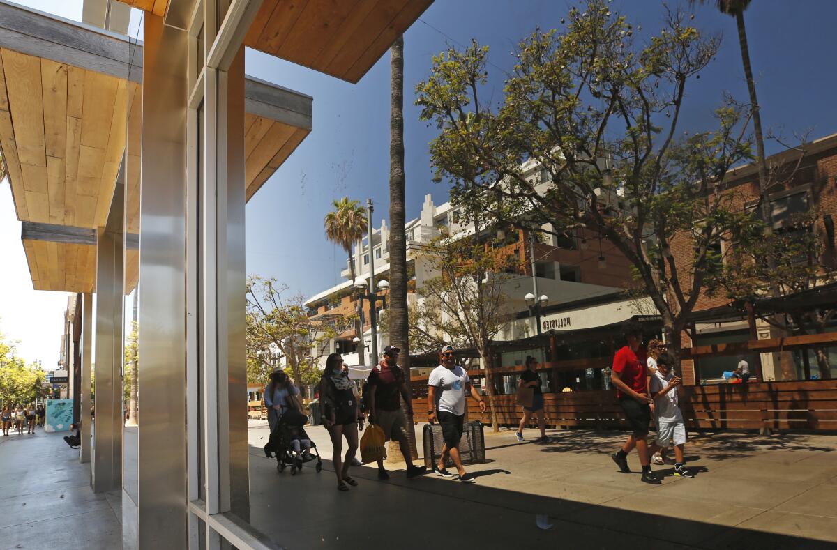 A store window reflects Santa Monica's Third Street Promenade.