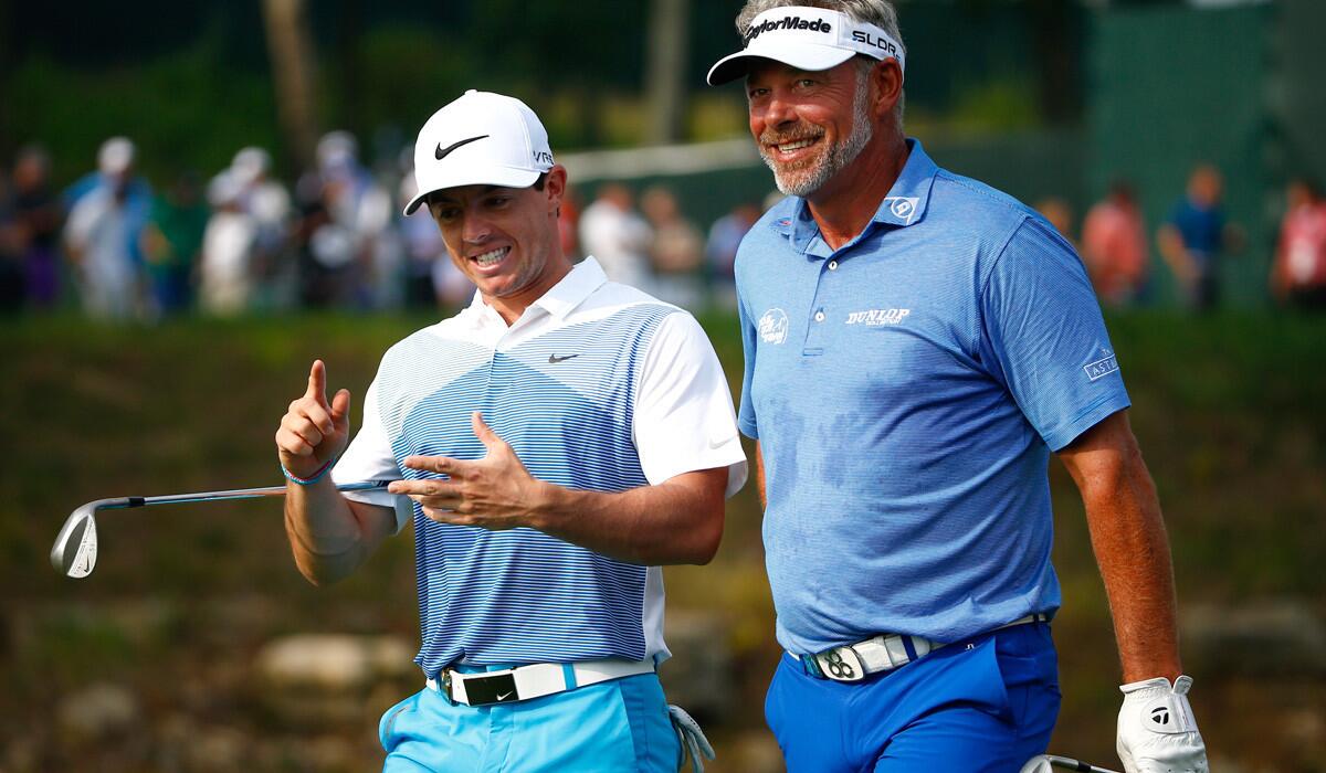 Rory McIlroy, left, and Darren Clarke chat between shots during a practice round at Valhalla Golf Club on Wednesday.