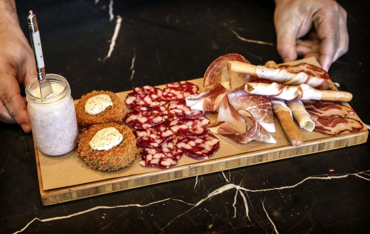 The Affettati Misti plate just prepared by Chef Chad Colby at CHI SPACCA. Featured on the plate from left to right is Pork butter, Trotter Fritti, Trappist Salami, Joe's Tocai Salami, Speck, Lardo wrapped grissini and Capocollo. (Ricardo DeAratanha/Los Angeles Times).