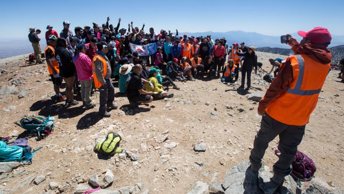 The Los Angeles area hiking community gather for a group photo as they honor the late and legendary Sam Kim during a memorial hike of Mt. Baldy, symbolically completing his dream of 1000 summits in Mt. Baldy, Calif., on May 20, 2017.