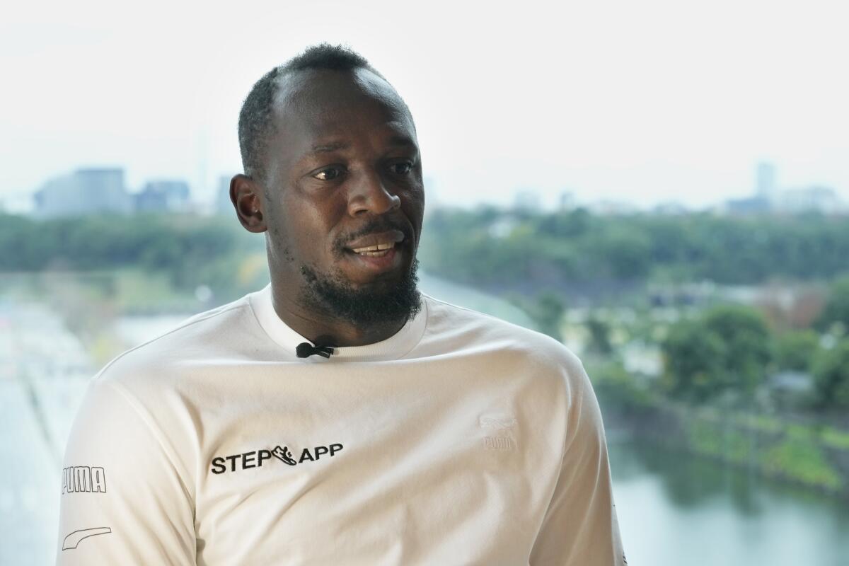 Usain Bolt wearing a casual shirt with a small microphone attached