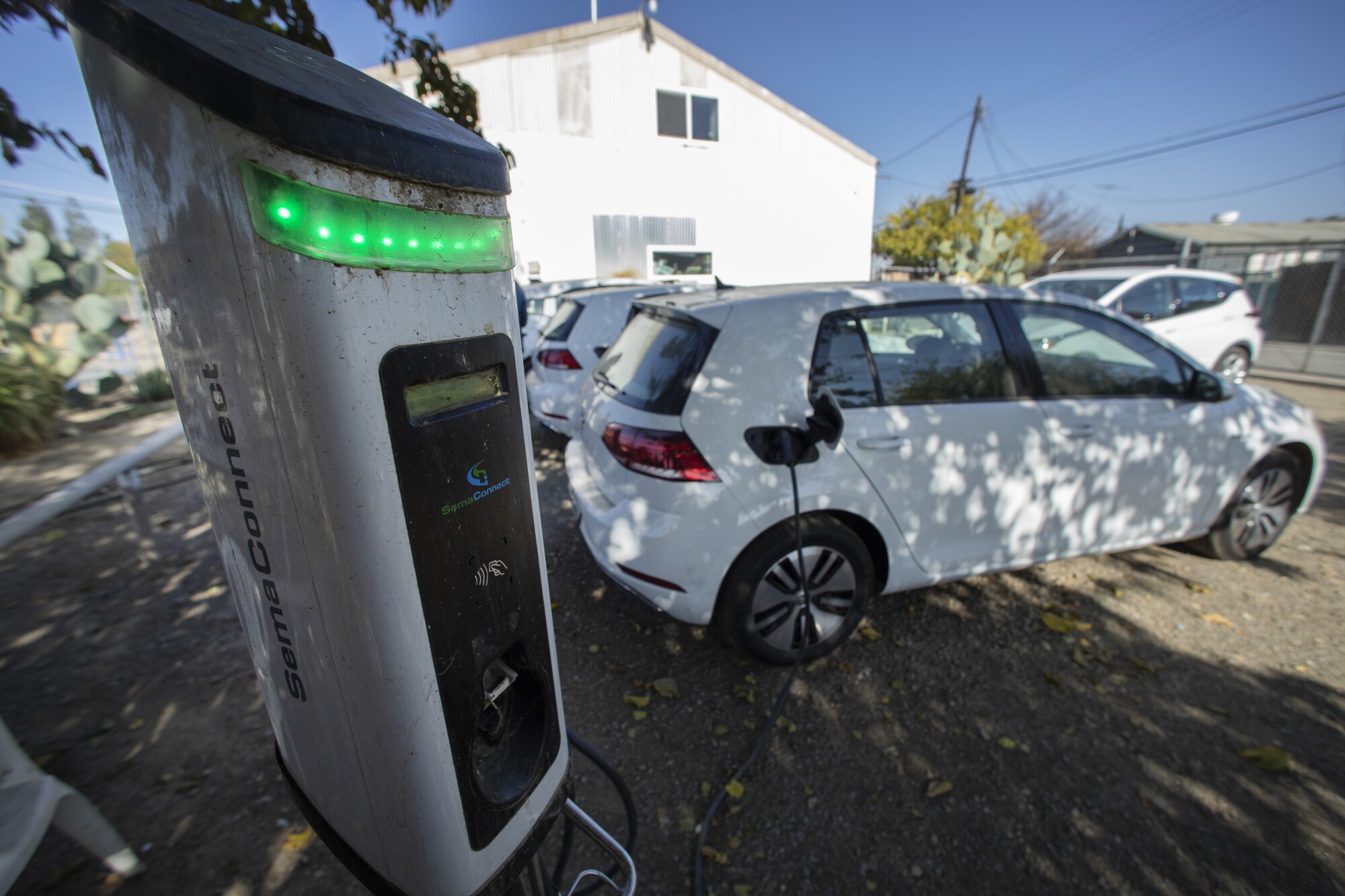 Green Raiteros cars are hooked to charges at the program headquarters, a former diesel mechanic shop.