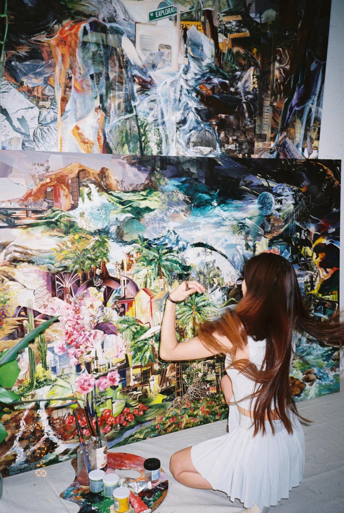 An artist kneeling and working on her colorful artwork.