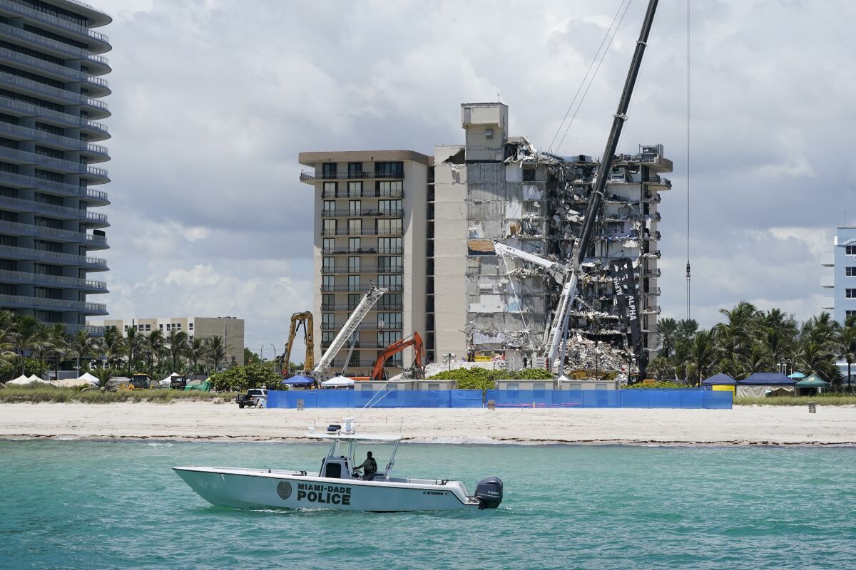 A Miami-Dade County Police boat patrols in front of the Champlain Towers South condo building, where search and rescue efforts continue more than a week after the building partially collapsed, Friday, July 2, 2021, in Surfside, Fla. (AP Photo/Mark Humphrey)