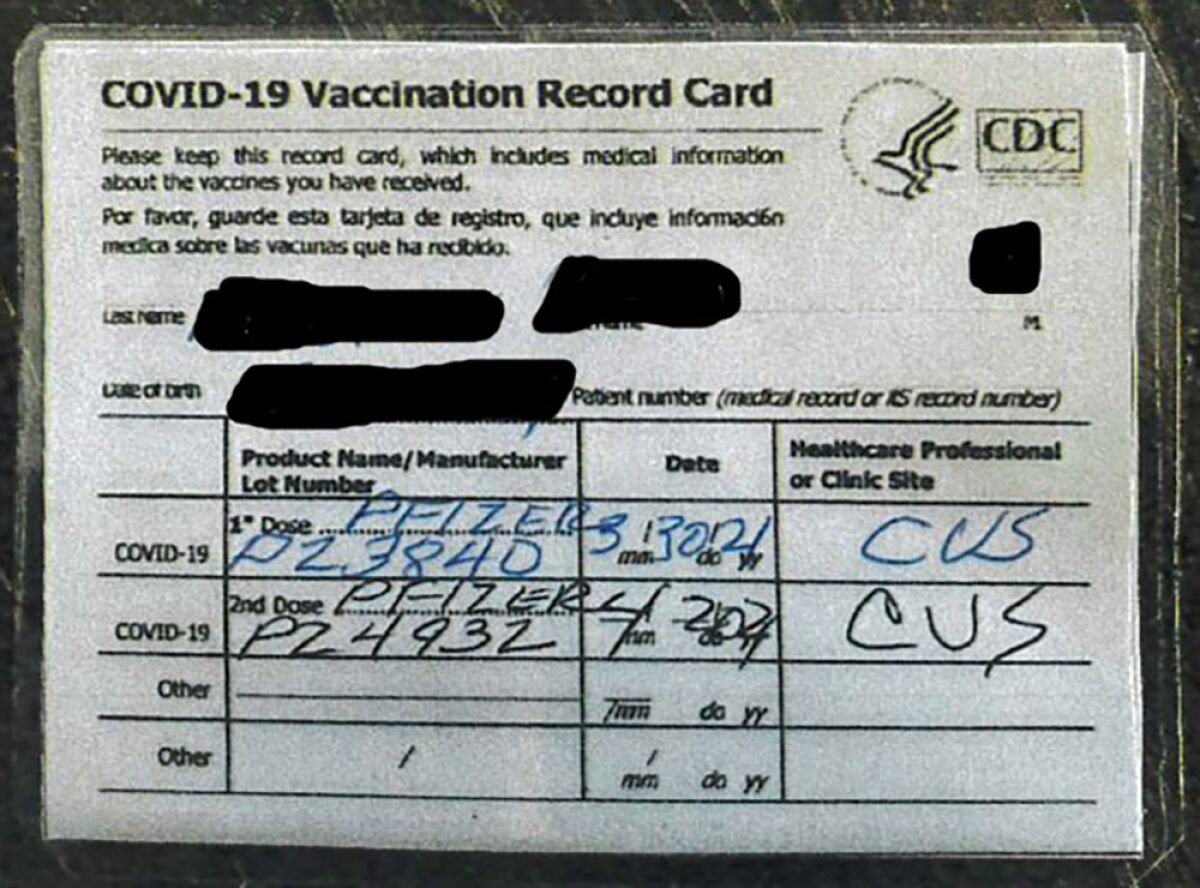 Image of a fraudulent COVID-19 vaccine card with identifying information blacked out.