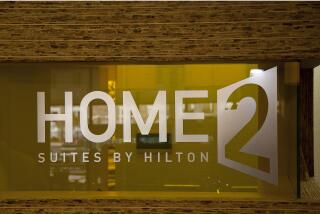 The logo of Home2 Suites by Hilton is etched on a window