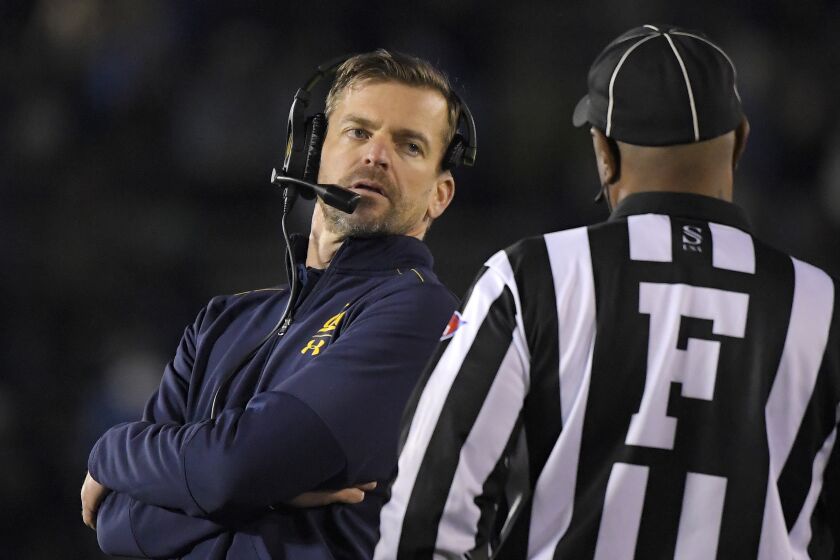 California coach Justin Wilcox, left, talks to an official during the first half of the team's NCAA college football game against UCLA on Saturday, Nov. 30, 2019, in Pasadena, Calif. (AP Photo/Mark J. Terrill)