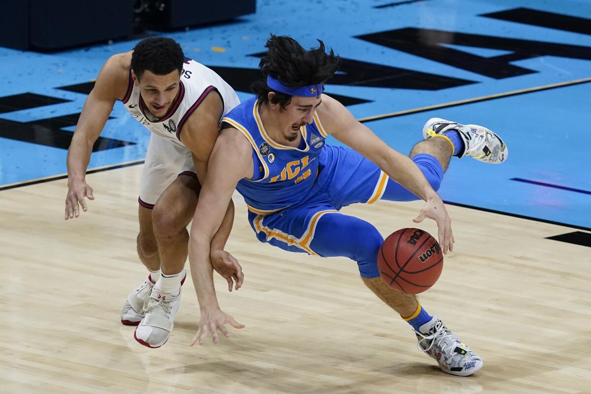 UCLA guard Jaime Jaquez Jr. fights for a loose ball with Gonzaga guard Jalen Suggs, left, during the first half.
