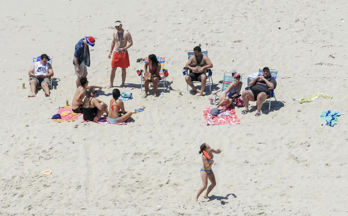 New Jersey Gov. Chris Christie, right, uses the beach Sunday with family and friends at the governor's summer house at Island Beach State Park, which was closed to the public because of a government shutdown.