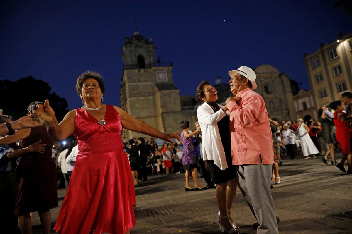 People dance to music played by Marimba del Gobierno de Estado de Oaxaca, in the zócalo in Oaxaca, Mexico.  