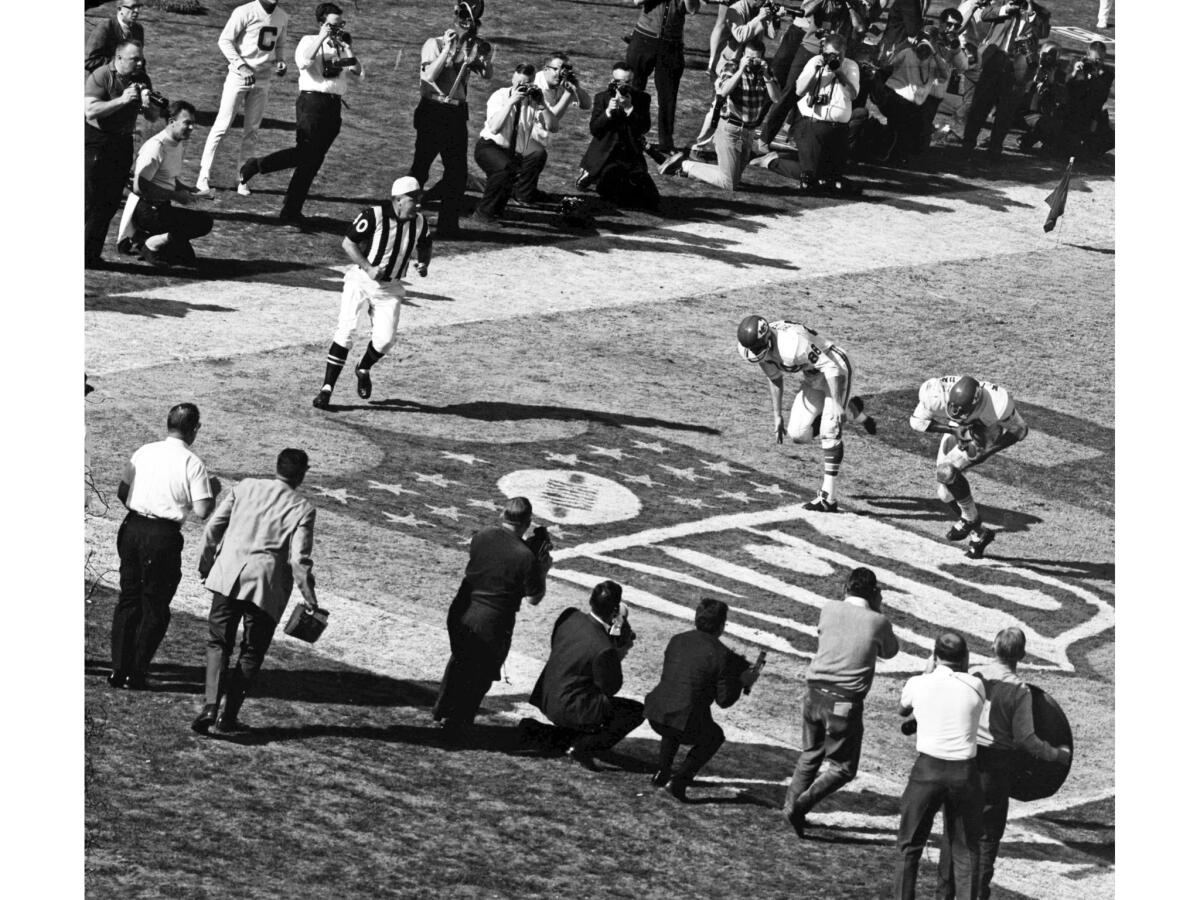 Jan. 15, 1967: The Chiefs' Curtis McClinton - surrounded by photographers - catches a touchdown pass during the first Super Bowl game at Los Angeles Memorial Coliseum. The Chiefs' Chris Burford, 88, is on the left.