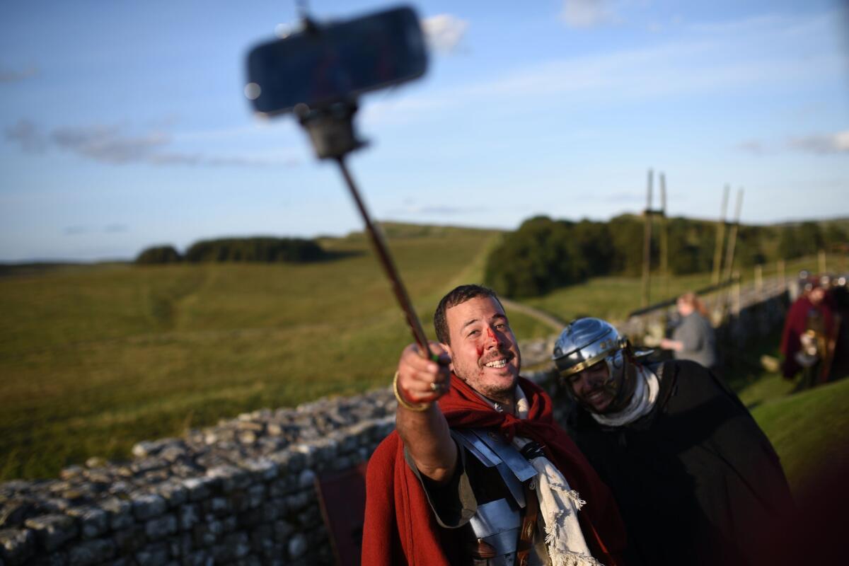 Selfie sticks span the centuries: Re-enactors portraying Imperial Roman Army soldiers photograph themselves with a selfie stick as they stand in front of Hadrian's Wall near Gilsland, northern England.