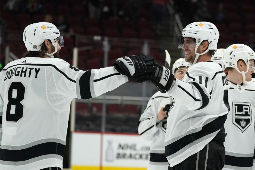 Los Angeles Kings center Anze Kopitar (11) celebrates his 1,000th career point with defenseman Drew Doughty (8) after the team's NHL hockey game against the Arizona Coyotes on Wednesday, May 5, 2021, in Glendale, Ariz. The Kings won 4-2. (AP Photo/Ross D. Franklin)