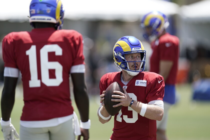 Rams quarterback John Woolford takes part in practice as Bryce Perkins (16) watches.