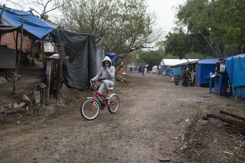 A girl rides her bike in a migrant camp where she lives across the border in Matamoros, Mexico on Thursday, Feb. 11, 2021. Veronica G. Cardenas / For The Times