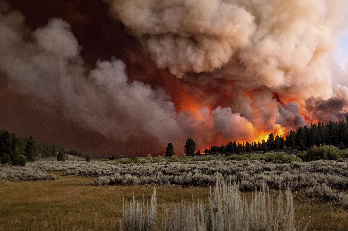 Plumes of smoke ise above Frenchman Lake as the Sugar fire burns in Plumas National Forest on Thursday.